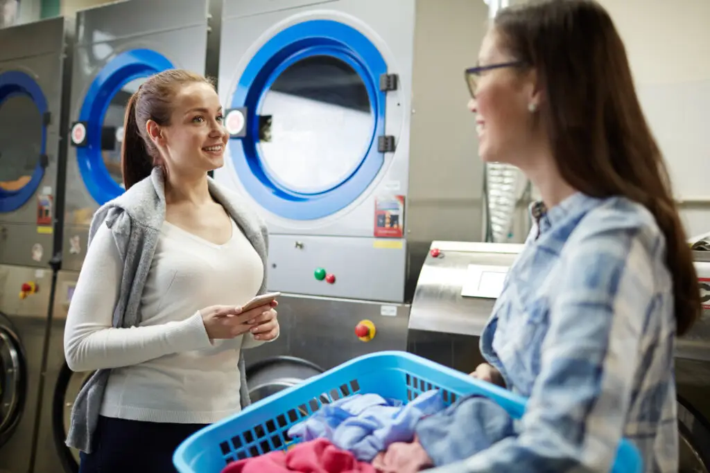 Two housekeepers having talk in laundry